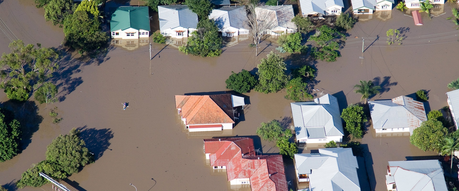 Bird's eye view looking down on New Zealand houses that have been flooded by storm damage.