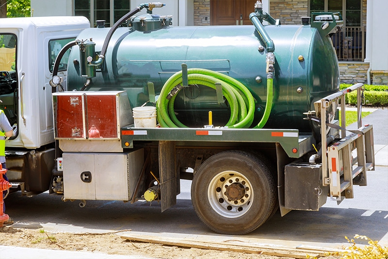 Sewage extraction truck ready to extract and clean up sewage from an overflow of sewage at a property.